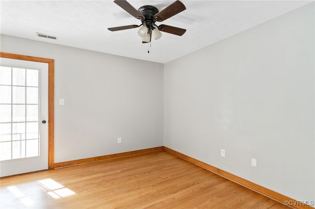 empty room featuring ceiling fan, light wood-type flooring, visible vents, and baseboards