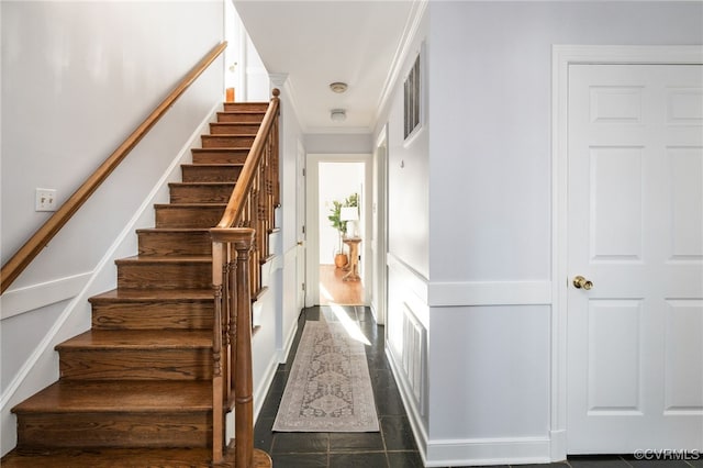 staircase featuring ornamental molding, visible vents, and tile patterned floors