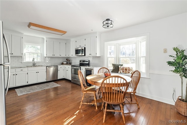 dining space featuring dark wood finished floors and baseboards