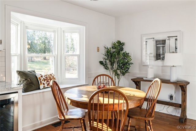 dining space featuring beverage cooler, plenty of natural light, and dark wood-style floors