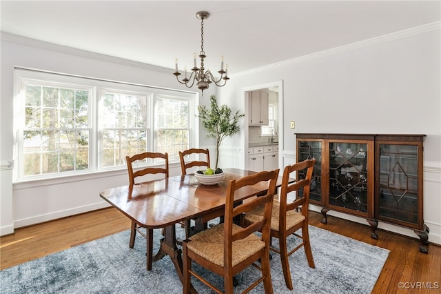 dining room with crown molding, a chandelier, and wood finished floors