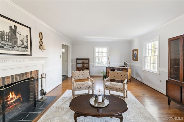 living area with plenty of natural light, dark wood-type flooring, a tiled fireplace, and ornamental molding