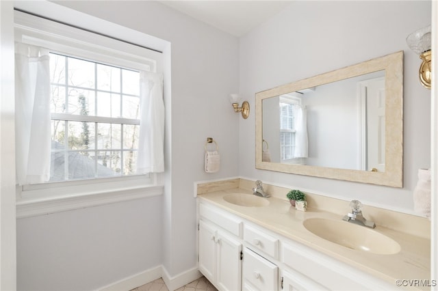 full bathroom featuring double vanity, baseboards, and a sink