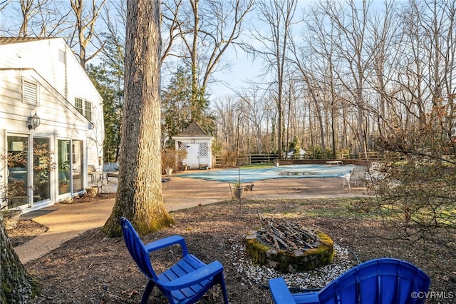 view of yard with a patio area, a covered pool, and fence