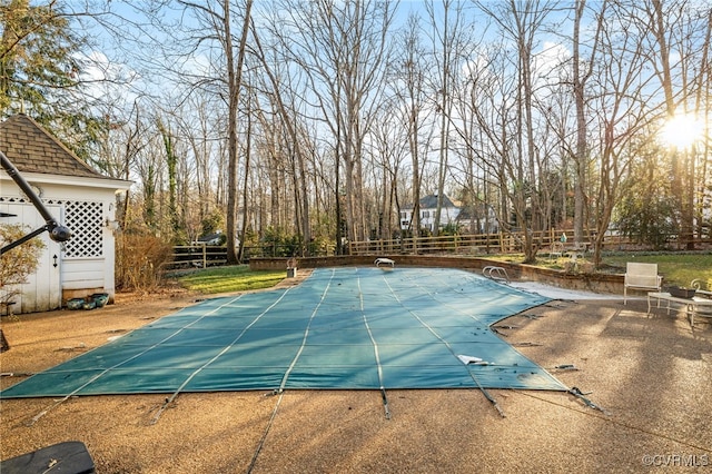 view of swimming pool with a diving board, a patio area, fence, and a fenced in pool