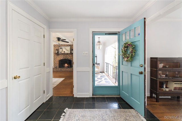 foyer entrance with a fireplace, dark wood-style flooring, and crown molding