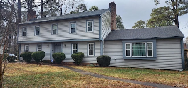 colonial inspired home with a front lawn