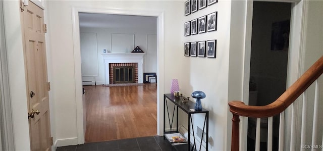 hallway featuring a baseboard heating unit and dark hardwood / wood-style floors