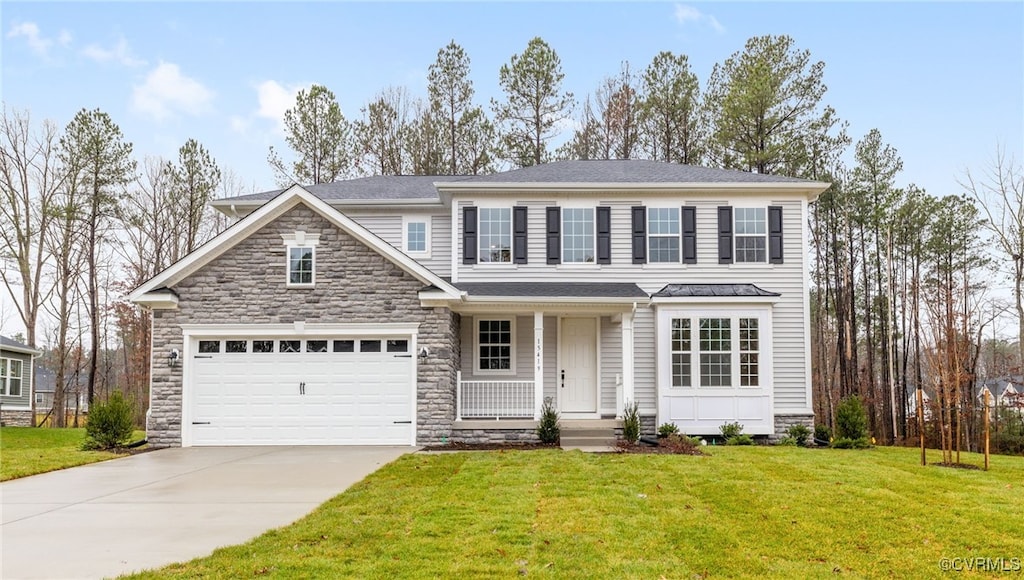 view of front of property with a garage, covered porch, and a front lawn