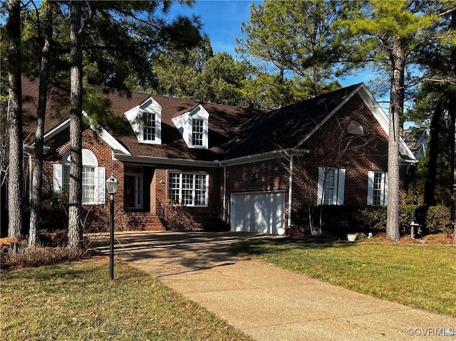 cape cod-style house featuring a garage and a front yard