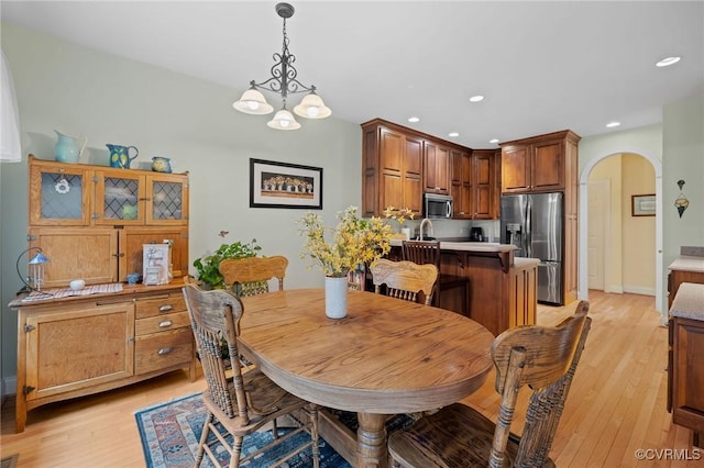 dining area with light hardwood / wood-style flooring and a chandelier