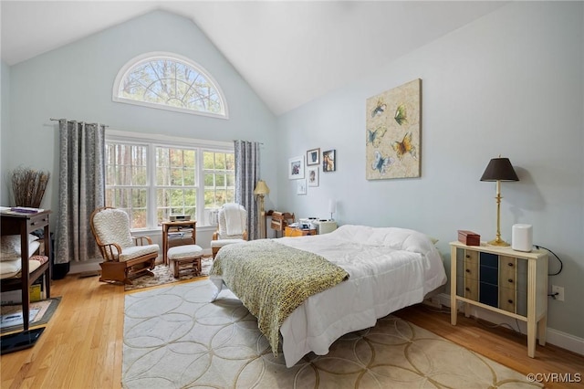 bedroom with hardwood / wood-style flooring and high vaulted ceiling