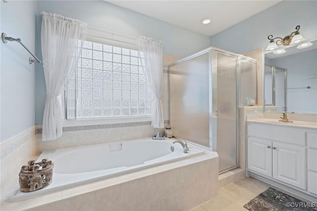 bathroom with tile patterned floors, vanity, and shower with separate bathtub