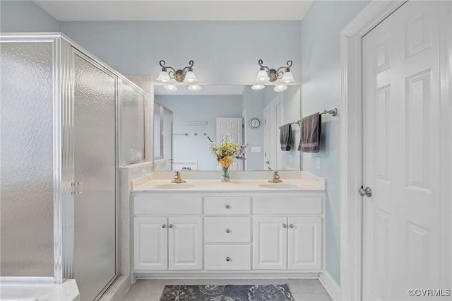 bathroom with a shower with door, vanity, and tile patterned flooring