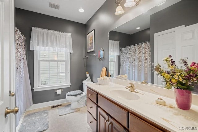 bathroom featuring vanity, a wealth of natural light, and toilet