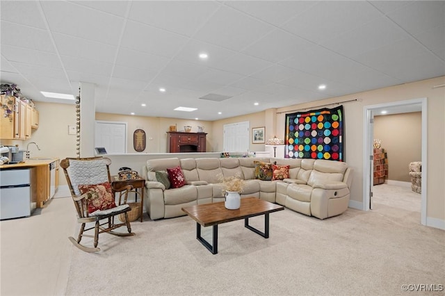 carpeted living room with sink and a paneled ceiling