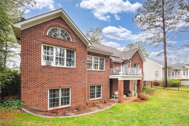 back of house featuring a balcony and a yard