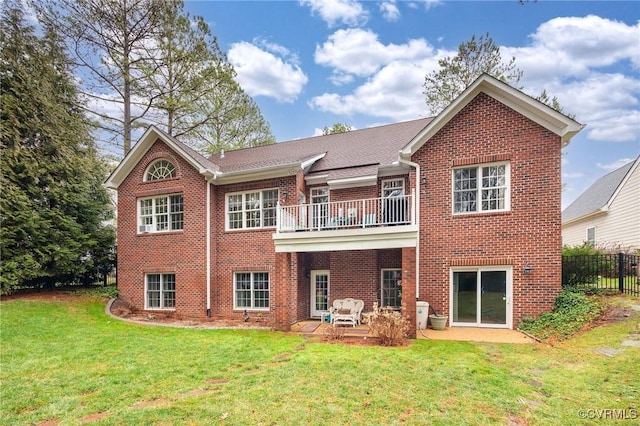 rear view of house with a balcony, a yard, and a patio area