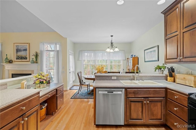 kitchen featuring pendant lighting, sink, an inviting chandelier, stainless steel dishwasher, and light wood-type flooring