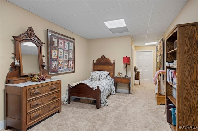 carpeted bedroom featuring a drop ceiling