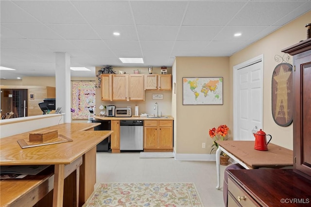 kitchen featuring a paneled ceiling, sink, stainless steel dishwasher, and light brown cabinets