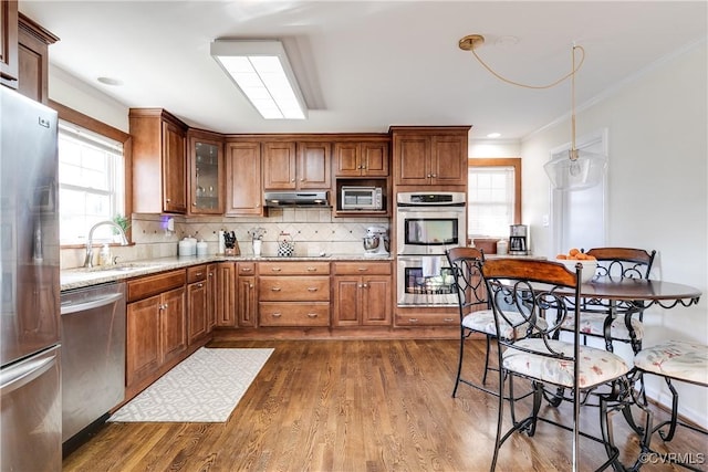 kitchen featuring dark wood-type flooring, sink, tasteful backsplash, appliances with stainless steel finishes, and light stone countertops