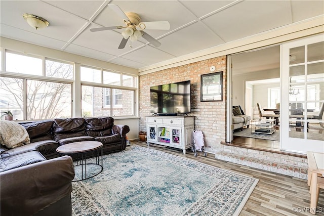 living room featuring ceiling fan, brick wall, a paneled ceiling, and hardwood / wood-style floors