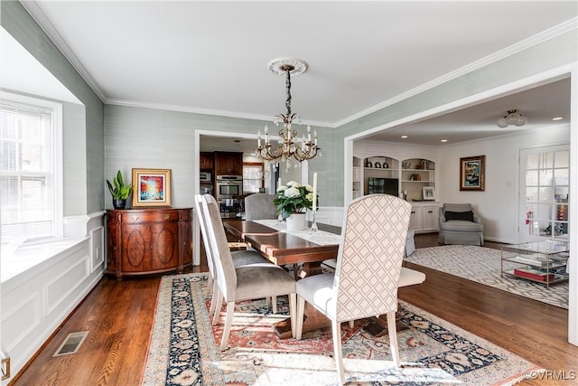 dining room featuring crown molding, a notable chandelier, dark wood-type flooring, and a wealth of natural light