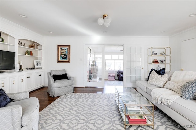 living room featuring built in features, dark wood-type flooring, and ornamental molding