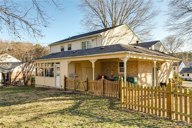 back of property with a lawn and a sunroom