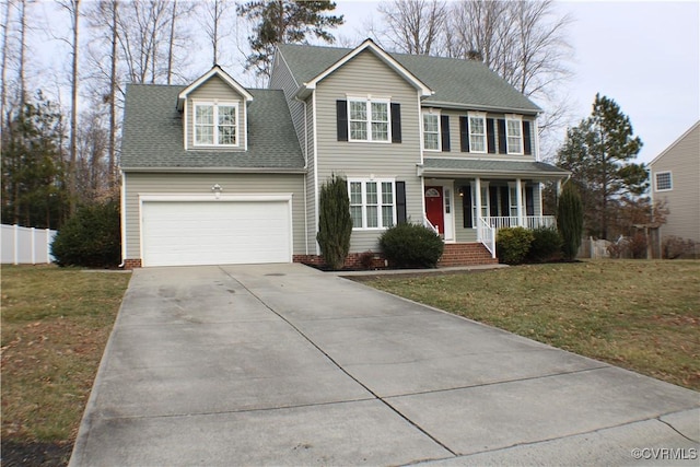 colonial-style house featuring a garage, a front yard, and a porch