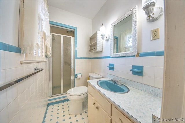 full bathroom featuring vanity, a shower stall, toilet, and tile walls