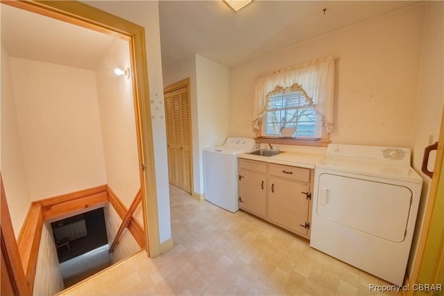 washroom featuring washer / dryer, cabinet space, a sink, and light floors