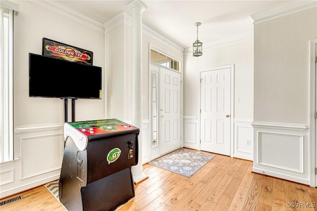 foyer entrance with ornate columns, ornamental molding, and wood-type flooring