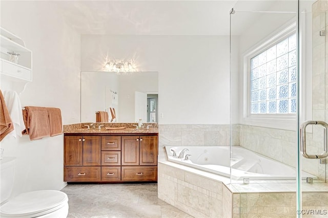 bathroom featuring tiled tub, vanity, and toilet