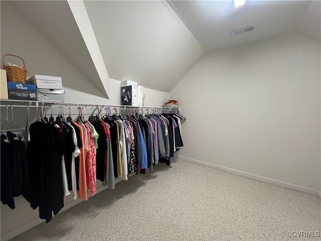 spacious closet with carpet flooring and vaulted ceiling