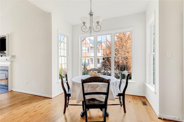 dining space featuring a notable chandelier and light wood-type flooring