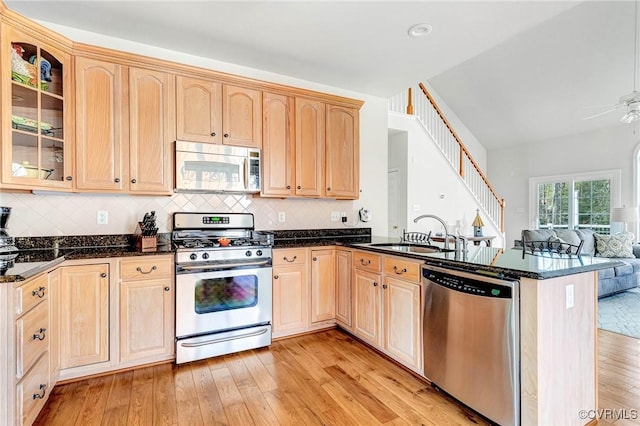 kitchen featuring appliances with stainless steel finishes, light brown cabinetry, kitchen peninsula, and sink