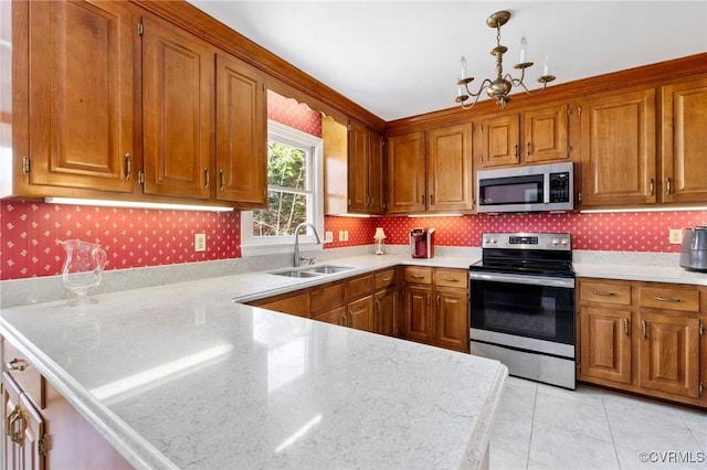 kitchen with stainless steel appliances, a sink, light countertops, and brown cabinets