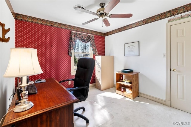 carpeted office with wallpapered walls, baseboards, and a ceiling fan