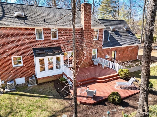 rear view of property featuring central air condition unit, a shingled roof, a chimney, and a deck