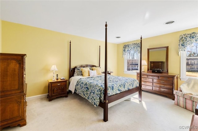 bedroom with light carpet, visible vents, and baseboards