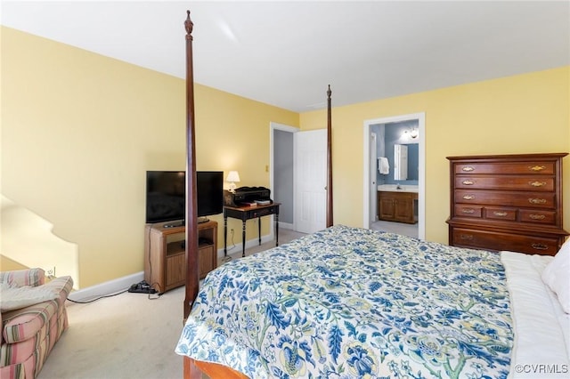 bedroom with light carpet, a sink, ensuite bath, and baseboards