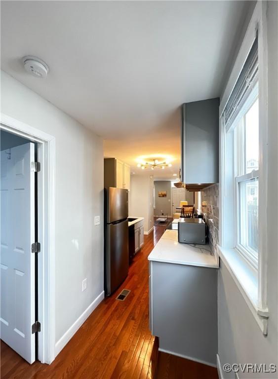 kitchen featuring dark hardwood / wood-style flooring, stainless steel fridge, and gray cabinets