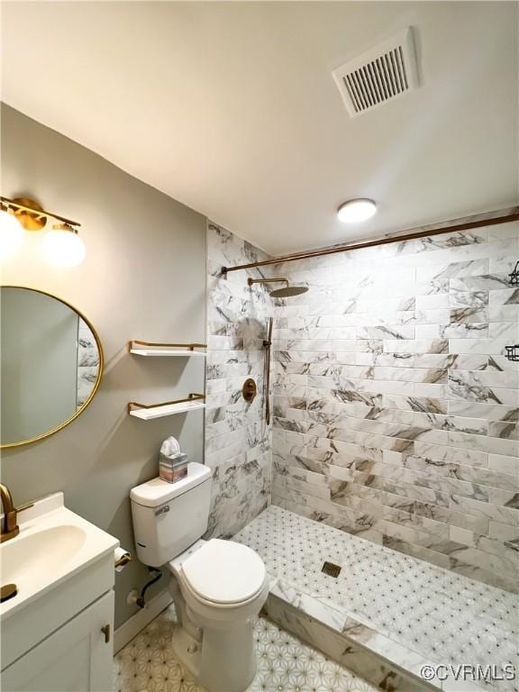 bathroom featuring vanity, toilet, and a tile shower