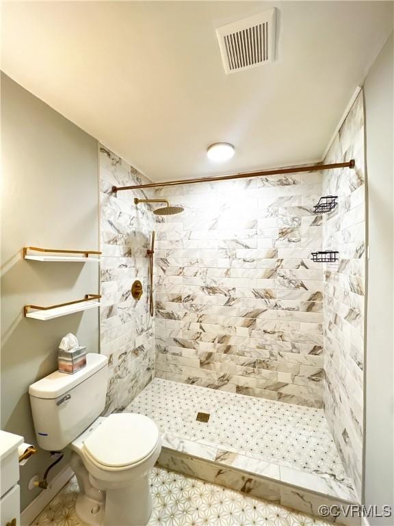 bathroom featuring vanity, toilet, and tiled shower