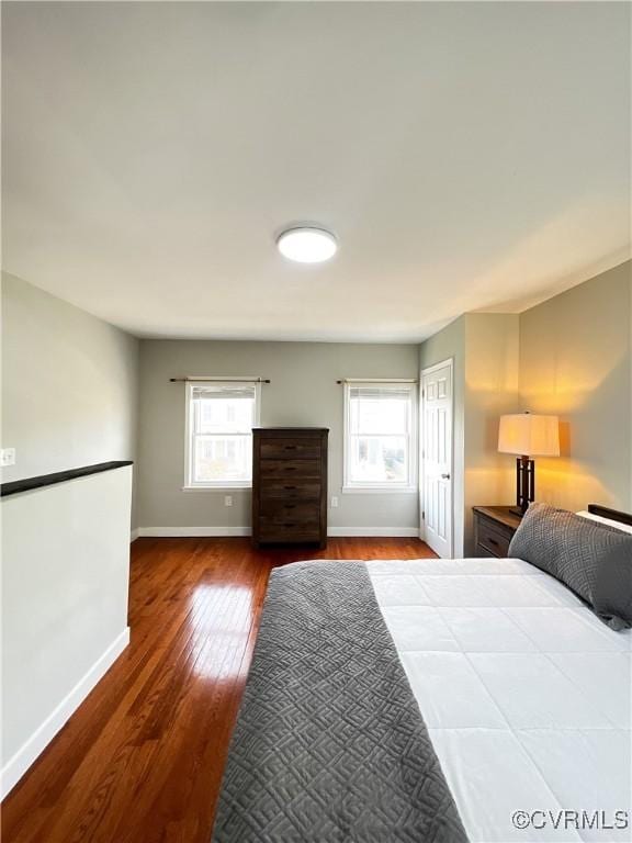 bedroom with multiple windows and hardwood / wood-style flooring