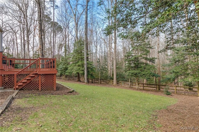 view of yard featuring a deck, a fenced backyard, and stairway