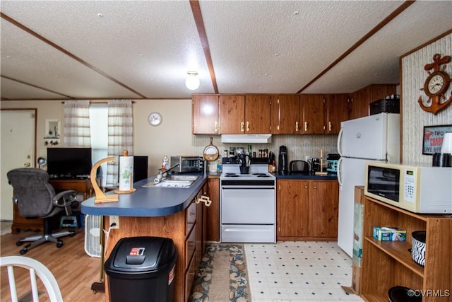 kitchen with sink, white appliances, and a textured ceiling