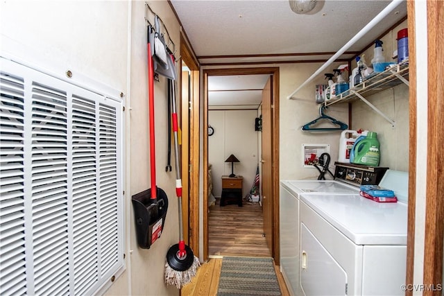 clothes washing area with wood-type flooring and washing machine and clothes dryer